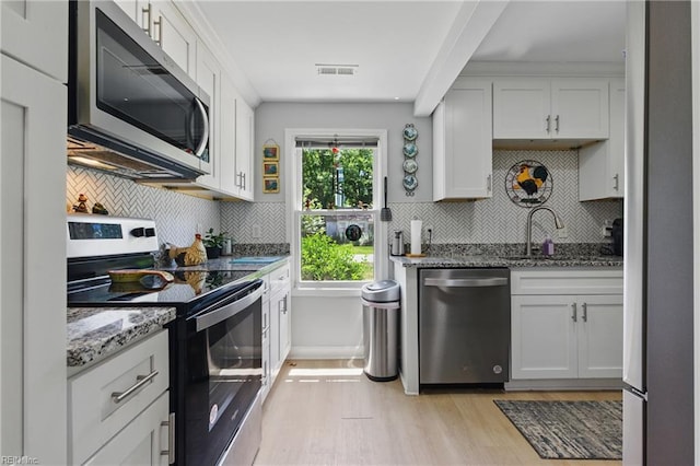 611 74th St, Newport News, VA 23605 - kitchen featuring stainless steel appliances, light wood-style floors, light stone countertops, a sink, and backsplash