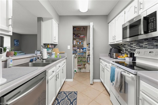 606 Queens Xing, Williamsburg, VA 23185 - kitchen with appliances with stainless steel finishes, a sink, tasteful backsplash, white cabinets, and a textured ceiling