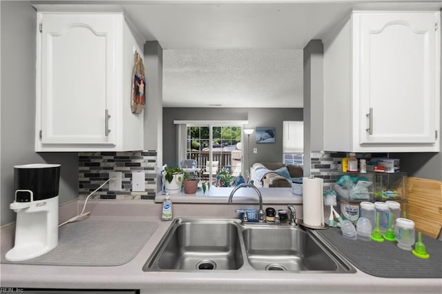 606 Queens Xing, Williamsburg, VA 23185 - kitchen with a sink, white cabinetry, decorative backsplash, and a textured ceiling