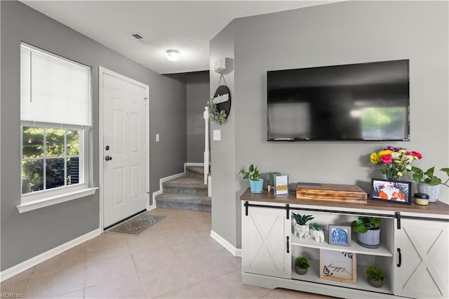 606 Queens Xing, Williamsburg, VA 23185 - entrance foyer with baseboards, light tile patterned floors, and stairs