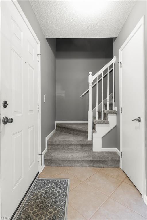 606 Queens Xing, Williamsburg, VA 23185 - tiled foyer with stairway, a textured ceiling, and baseboards