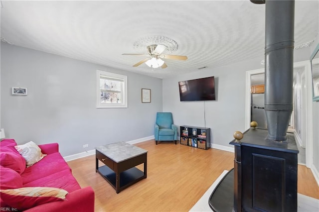 1219 Milton St, Norfolk, VA 23505 - living area with wood finished floors, ceiling fan, a wood stove, and baseboards
