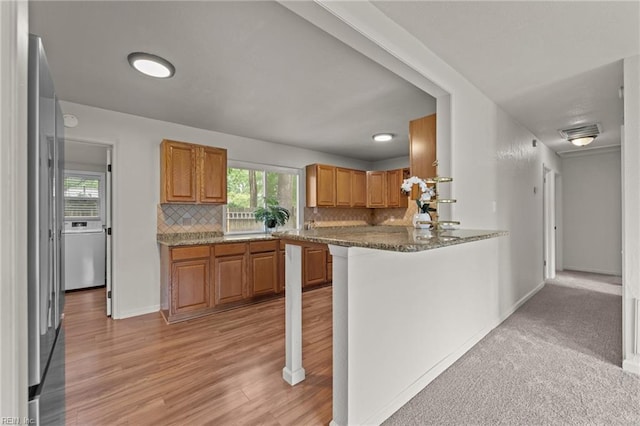 3521 Melinda Pl, Virginia Beach, VA 23452 - kitchen featuring backsplash, stainless steel refrigerator, brown cabinetry, light wood-style flooring, and baseboards