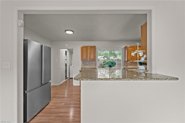 3521 Melinda Pl, Virginia Beach, VA 23452 - kitchen featuring freestanding refrigerator, brown cabinets, light wood finished floors, and tasteful backsplash