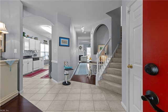2673 Einstein Dr, Virginia Beach, VA 23456 - foyer with arched walkways, stairs, light tile patterned floors, and baseboards