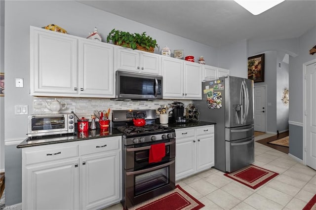 2673 Einstein Dr, Virginia Beach, VA 23456 - kitchen with stainless steel appliances, backsplash, arched walkways, and white cabinetry