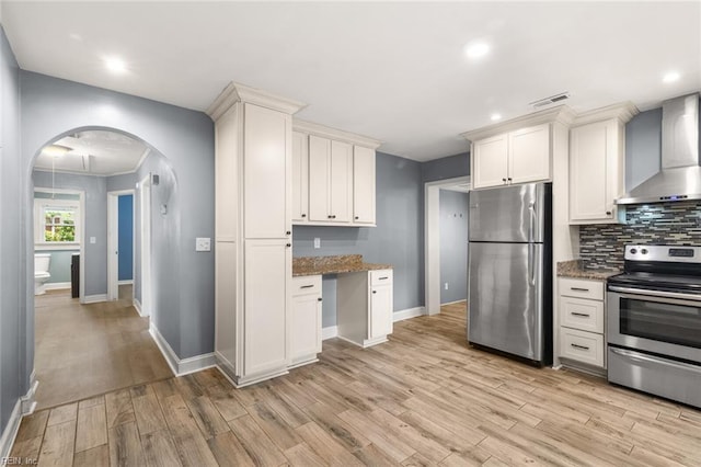 1204 Elder Ave, Chesapeake, VA 23325 - kitchen with stainless steel appliances, wall chimney range hood, arched walkways, light stone counters, and recessed lighting