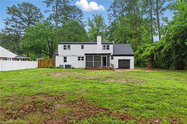 4328 Thoroughgood Dr, Virginia Beach, VA 23455 - rear view of house with a sunroom, an attached garage, a chimney, view of wooded area, and central AC