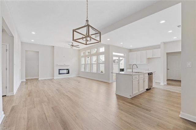 1400 Acadian Dr Unit A, Suffolk, VA 23434 - kitchen with dishwasher, white cabinetry, a sink, light wood-type flooring, and a glass covered fireplace