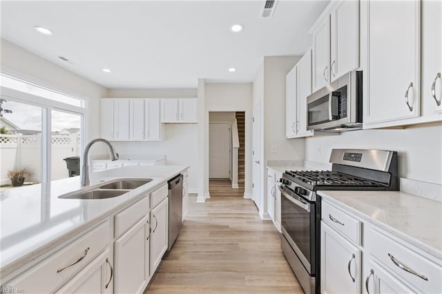1400 Acadian Dr Unit A, Suffolk, VA 23434 - kitchen featuring appliances with stainless steel finishes, a sink, light wood-style floors, white cabinets, and recessed lighting