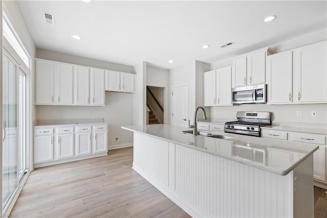 1400 Acadian Dr Unit A, Suffolk, VA 23434 - kitchen featuring appliances with stainless steel finishes, a sink, an island with sink, light wood-style flooring, and white cabinetry