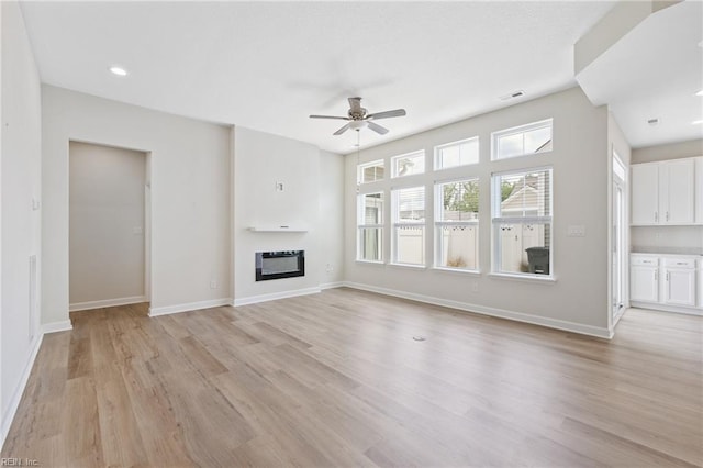 1400 Acadian Dr Unit A, Suffolk, VA 23434 - unfurnished living room with light wood-type flooring, ceiling fan, a glass covered fireplace, and baseboards