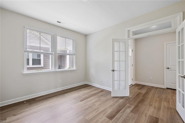 1400 Acadian Dr Unit A, Suffolk, VA 23434 - unfurnished bedroom featuring french doors, wood finished floors, and baseboards