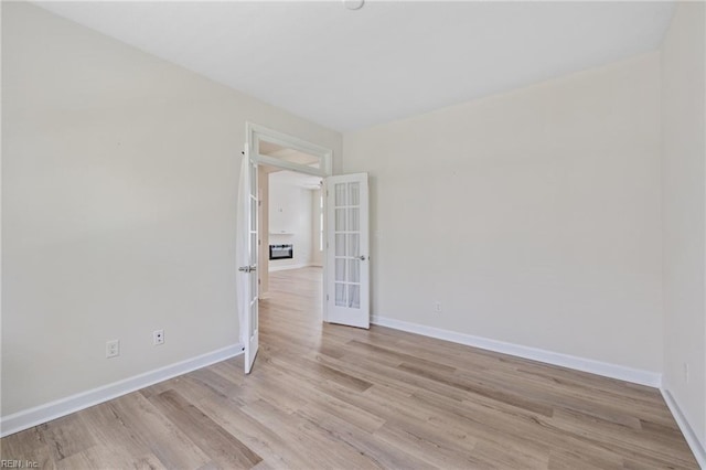 1400 Acadian Dr Unit A, Suffolk, VA 23434 - empty room featuring french doors, light wood finished floors, and baseboards