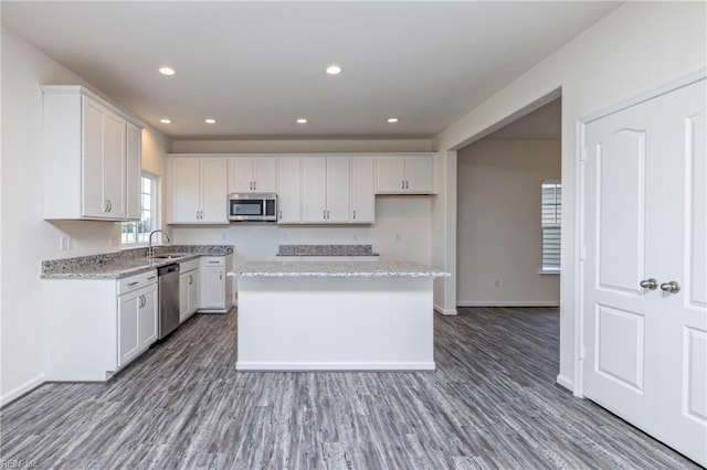 102 Corcoran Ln, Suffolk, VA 23434 - kitchen with appliances with stainless steel finishes, a sink, white cabinetry, wood finished floors, and a kitchen island