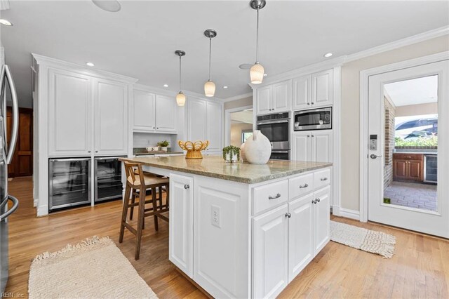 1825 N Alanton Dr, Virginia Beach, VA 23454 - kitchen featuring stainless steel microwave, recessed lighting, a center island, white cabinetry, and light stone countertops