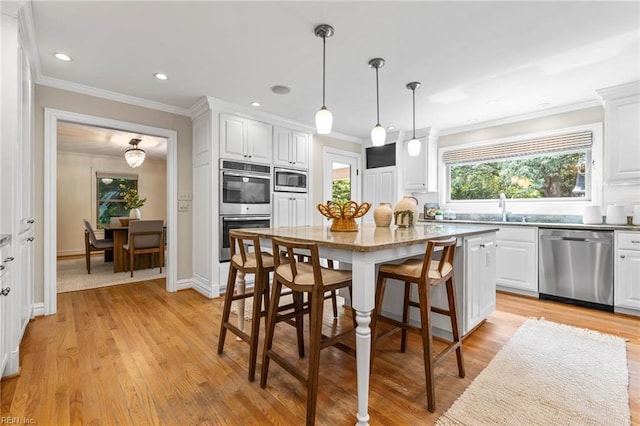 1825 N Alanton Dr, Virginia Beach, VA 23454 - kitchen featuring appliances with stainless steel finishes, white cabinets, light wood-style floors, a breakfast bar, and ornamental molding