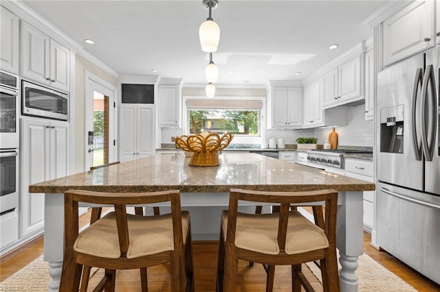 1825 N Alanton Dr, Virginia Beach, VA 23454 - kitchen featuring appliances with stainless steel finishes, white cabinets, tasteful backsplash, ornamental molding, and a kitchen island