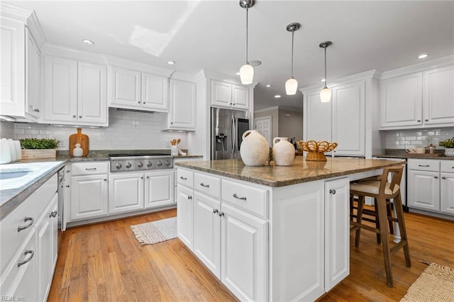 1825 N Alanton Dr, Virginia Beach, VA 23454 - kitchen featuring appliances with stainless steel finishes, a kitchen breakfast bar, a center island, backsplash, and white cabinetry