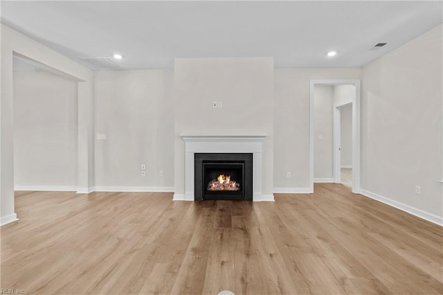 142 Quarter Horse Loop, Hertford, NC 27944 - unfurnished living room with a warm lit fireplace, light wood-style flooring, baseboards, and recessed lighting