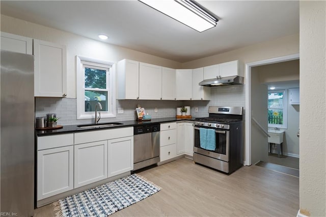 3408 Wakefield Dr, Portsmouth, VA 23703 - kitchen with stainless steel appliances, under cabinet range hood, a sink, and decorative backsplash