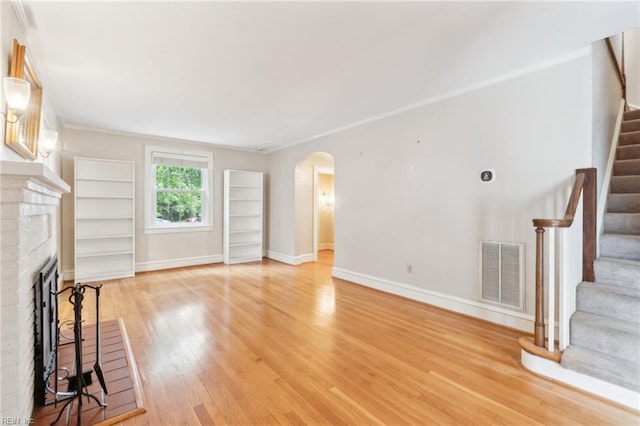 3 Acorn St, Hampton, VA 23669 - unfurnished living room featuring arched walkways, stairway, light wood finished floors, a brick fireplace, and baseboards