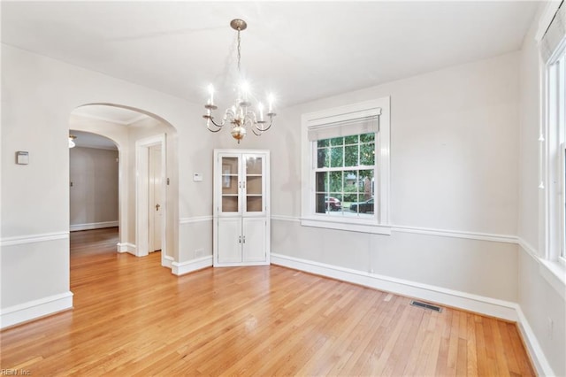 3 Acorn St, Hampton, VA 23669 - unfurnished dining area with a chandelier, light wood finished floors, arched walkways, and baseboards