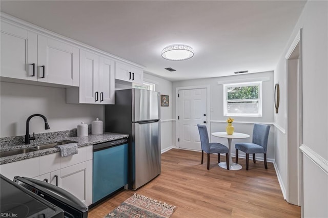 10 Hopkins St, Hampton, VA 23663 - kitchen featuring dishwasher, a sink, light stone countertops, white cabinets, and light wood-style flooring