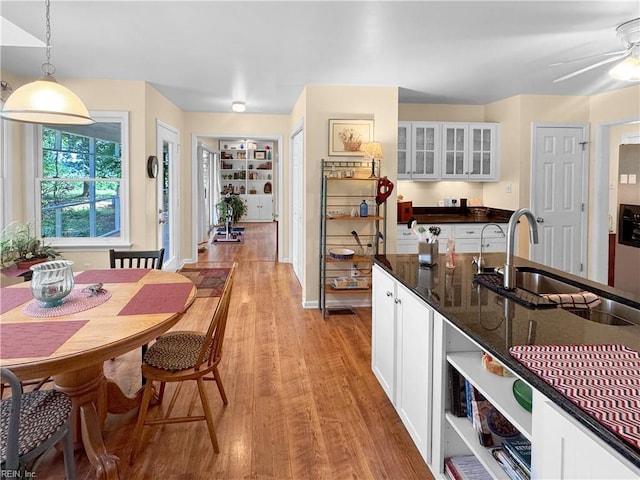585 Morse Point Rd, Port Haywood, VA 23138 - kitchen with a sink, light wood-style floors, white cabinets, glass insert cabinets, and pendant lighting