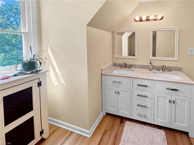 585 Morse Point Rd, Port Haywood, VA 23138 - bathroom with wood finished floors, double vanity, baseboards, and vaulted ceiling