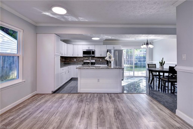 39 Morrison Ave, Newport News, VA 23601 - kitchen featuring appliances with stainless steel finishes, white cabinets, wood finished floors, ornamental molding, and backsplash