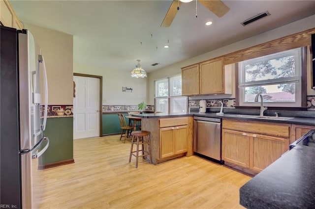 4217 Meadowgate Ct, Chesapeake, VA 23321 - kitchen featuring stainless steel appliances, a sink, a peninsula, light wood finished floors, and dark countertops