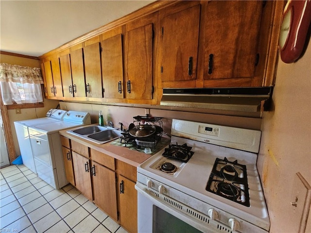 1428 24th St, Newport News, VA 23607 - kitchen with white range with gas stovetop, washer and clothes dryer, light tile patterned floors, light countertops, and a sink