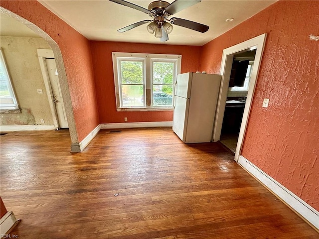3860 Nansemond Cir, Norfolk, VA 23513 - unfurnished dining area featuring a textured wall, arched walkways, wood finished floors, ceiling fan, and baseboards