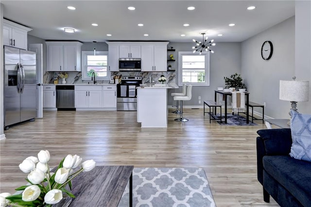717 S Fallon Ct, Hampton, VA 23661 - living room with recessed lighting, a chandelier, light wood-type flooring, and baseboards