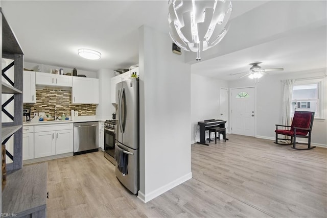 6628 Glenoak Dr, Norfolk, VA 23513 - kitchen with stainless steel appliances, backsplash, a sink, white cabinetry, and light wood finished floors