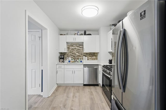 6628 Glenoak Dr, Norfolk, VA 23513 - kitchen with appliances with stainless steel finishes, white cabinetry, light wood finished floors, tasteful backsplash, and a sink