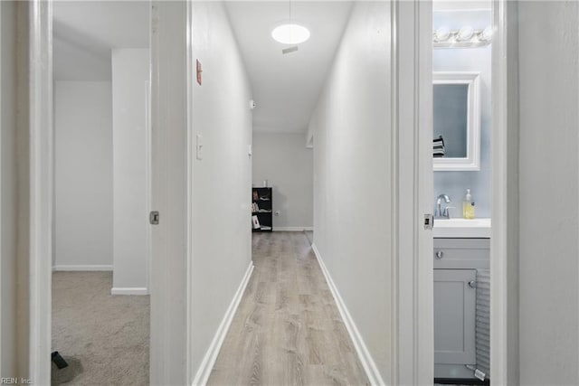 6628 Glenoak Dr, Norfolk, VA 23513 - corridor with a sink, light wood finished floors, and baseboards