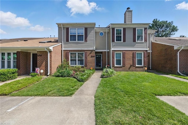 677 Hollomon Dr, Hampton, VA 23666 - view of property featuring a chimney, brick siding, and a front lawn
