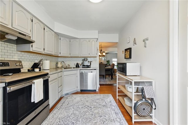 677 Hollomon Dr, Hampton, VA 23666 - kitchen with appliances with stainless steel finishes, decorative backsplash, light countertops, a sink, and under cabinet range hood