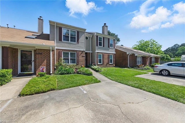 677 Hollomon Dr, Hampton, VA 23666 - view of front facade with a chimney, brick siding, and a front yard