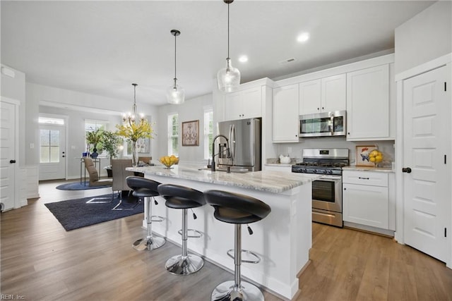 653 Waters Rd, Chesapeake, VA 23322 - kitchen featuring appliances with stainless steel finishes, a sink, white cabinets, a kitchen bar, and recessed lighting