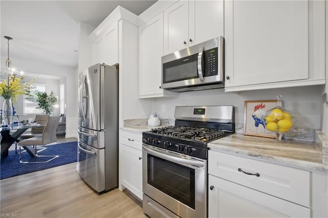 653 Waters Rd, Chesapeake, VA 23322 - kitchen featuring stainless steel appliances, white cabinetry, light wood-type flooring, light stone counters, and a chandelier