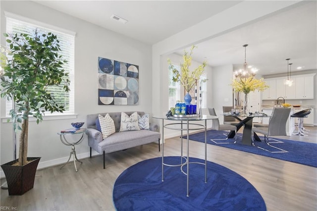 653 Waters Rd, Chesapeake, VA 23322 - living room featuring light wood-style floors, plenty of natural light, a chandelier, and baseboards