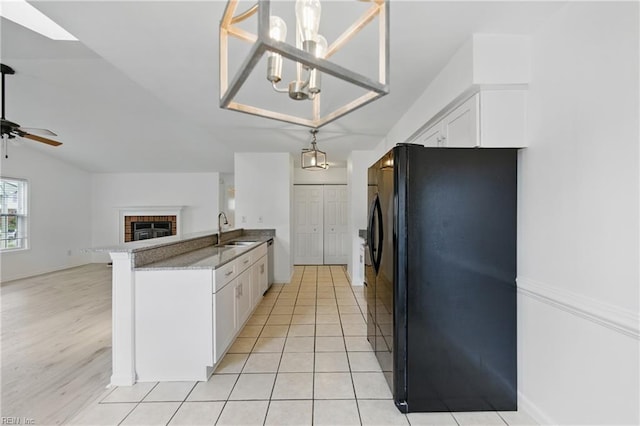 1713 Silver Springs Ct, Virginia Beach, VA 23456 - kitchen with freestanding refrigerator, a sink, a peninsula, white cabinetry, and open floor plan