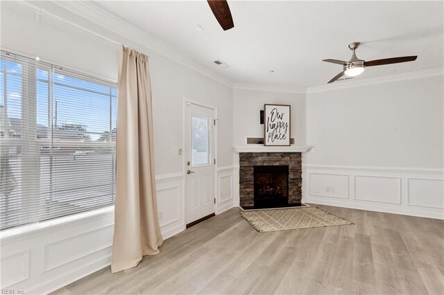 23 Mallory Way, Hampton, VA 23664 - unfurnished living room featuring a ceiling fan, crown molding, a decorative wall, light wood-style flooring, and a stone fireplace