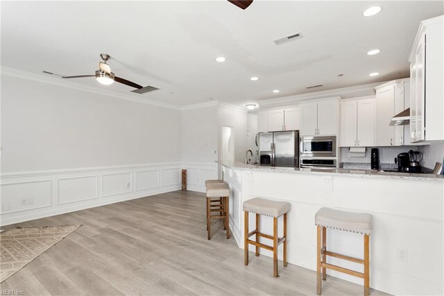 23 Mallory Way, Hampton, VA 23664 - kitchen featuring stainless steel appliances, crown molding, a ceiling fan, a breakfast bar area, and ventilation hood