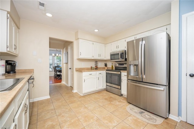 1020 Baydon Ln, Chesapeake, VA 23322 - kitchen featuring stainless steel appliances, white cabinets, light countertops, recessed lighting, and light tile patterned floors