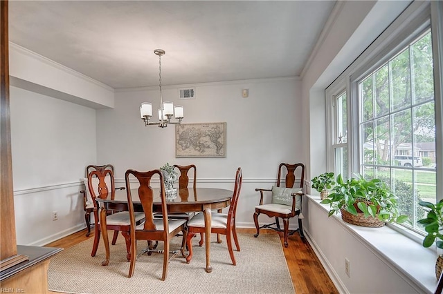 1052 Sunnyside Dr, Virginia Beach, VA 23464 - dining room with healthy amount of natural light, a chandelier, crown molding, and wood finished floors