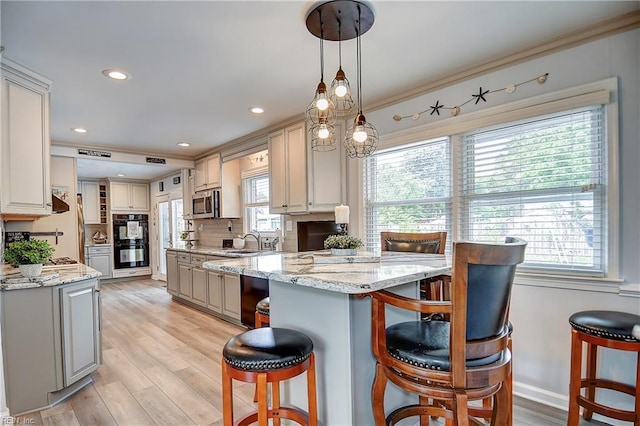 1052 Sunnyside Dr, Virginia Beach, VA 23464 - kitchen with a sink, a breakfast bar, stainless steel microwave, light wood-type flooring, and recessed lighting